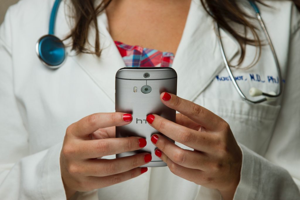 a phone in the hands of a female doctor